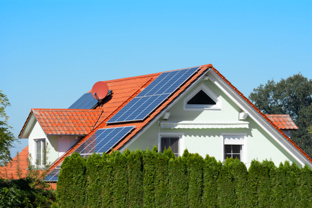 Modern house with photovoltaic solar cells on the roof for alternative energy production